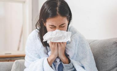 Women with a cold blowing her nose